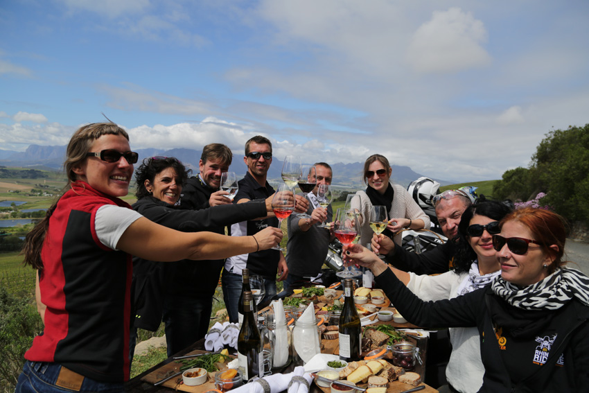 Teilnehmer einer Kleingruppenreise in Afrika mit Afrikascout genießen ein Getränk zum Sonnenuntergang